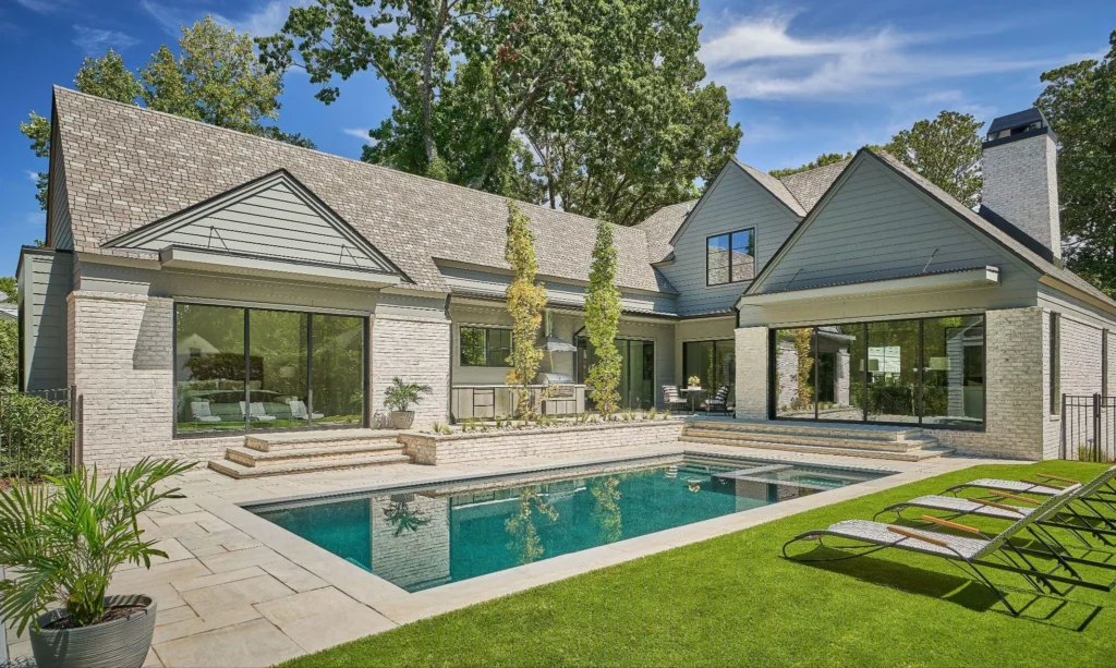 Luxury backyard pool with modern home and lounge chairs